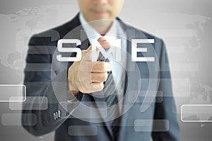 Businessman hand pointing to SME sign on virtual screen