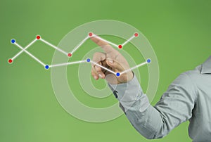 businessman hand pointing to the top line of a graph on green ba