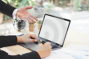 Businessman hand pointing on white blank screen laptop to explanation and takes note on business document in office while meeting.