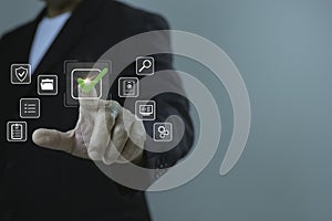 Businessman hand pressing digital check mark icon on virtual interface, concept