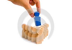 Businessman hand puts the leader in the center of a group of people of the arrow formation on a white background. Teamwork concept