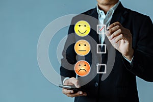 Businessman hand putting check mark a checkbox on excellent smiley face rating for a satisfaction survey