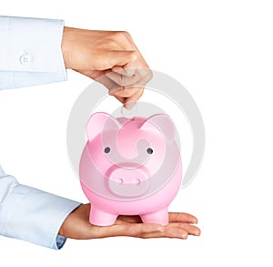 Businessman hand putting coin in piggy bank  on white background. Money saving, finance, investment concept