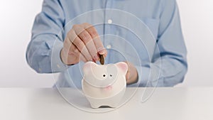 Businessman hand putting money in piggy bank for saving money and plan finance