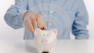 Businessman hand putting money in piggy bank for saving money and plan finance