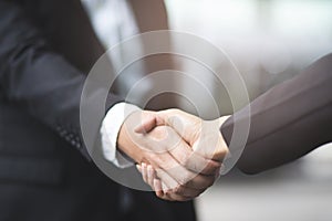businessman hand shake businesswoman between two colleagues
