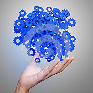 Businessman hand showing blue gears cogs