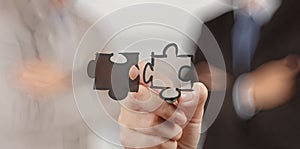 Businessman hand showing puzzle partnership