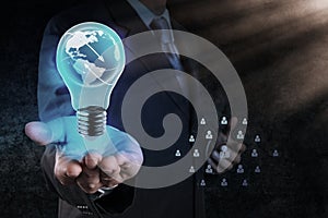 Businessman hand shows Light bulb with planet Earth social network