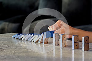 Businessman hand stop dominoes continuous toppled effect from continuous toppled or risk