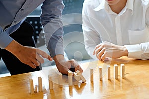 Businessman hand stopping the domino effect. executive and risk