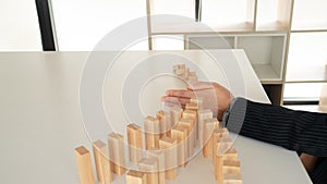 Businessman hand Stopping Falling wooden Blocks