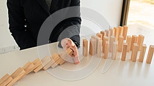 Businessman hand Stopping Falling wooden Blocks