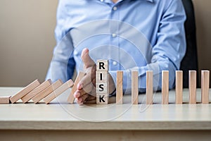 Businessman hand Stopping Falling wooden Blocks or Dominoes. Business, Risk Management, Solution, Insurance and strategy Concepts