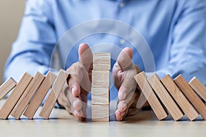 Businessman hand Stopping Falling wooden Blocks or Dominoes. Business, Risk Management, Solution, Insurance and strategy Concepts