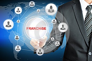 Businessman hand touching FRANCHISE sign on virtual screen