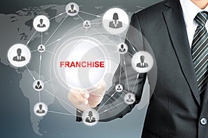 Businessman hand touching FRANCHISE sign on virtual screen