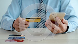 Businessman hand  use smartphone and holding credit card and to online shopping from home, payment e-commerce, internet banking,