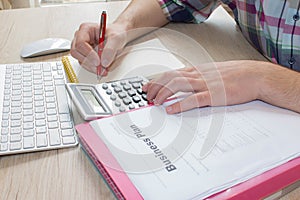 Businessman hand using calculator, accounting concept. Man hands with pencil, notebook and Calculator on table