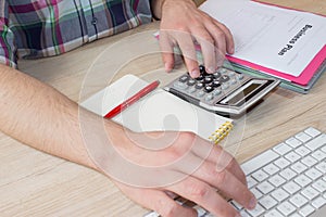 Businessman hand using calculator, accounting concept. Man hands with pencil, notebook and Calculator on table