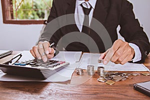 Businessman hand using calculator Calculating bonusOr other compensation to employees to increase productivity.Writing paper on