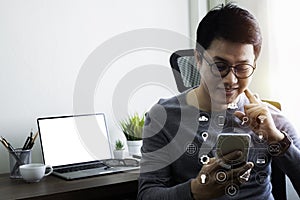 Businessman hand using mobile, laptop computer on office desk.