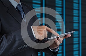 Businessman hand using tablet computer and server room