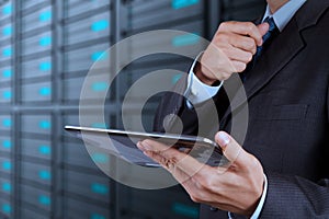 Businessman hand using tablet computer and server room