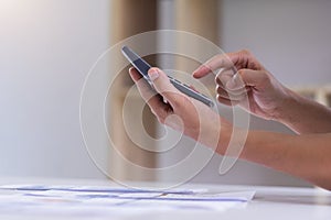 Businessman hand working with finances about cost and calculator on white desk in office. Businessman are using hands press on