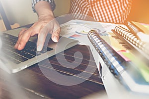 Businessman hand working laptop on wooden desk, Use the accompany article in finance. vintage effect.