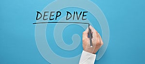 Businessman hand writing the business buzzword deep dive