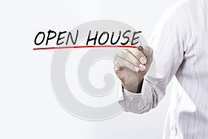 Businessman hand writing OPEN HOUSE with red marker on transparent wipe board, business concept