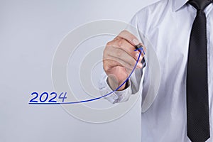 Businessman hand writing plan 2024 with bule marker on transparent wipe board, business concept