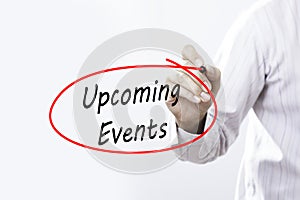 Businessman Hand Writing Upcoming Events with a marker over tran