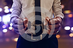 Business man in handcuffs at night