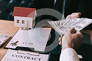 Businessman handed the house model and new homeowner giving money to real estate trading