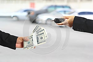 Businessman handed the money to Businesswoman or saleswoman holding in a hand car keys, auto business, car trading, loans for car
