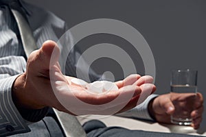 Businessman with a handful of pills, hands close view - concept of difficulties, depression, problems, health and stress, risk of