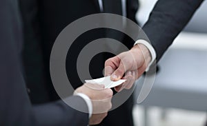 Businessman handing business card to the partner.