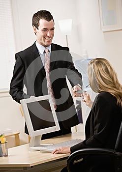 Businessman handing receptionist his card