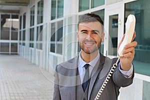 Businessman handing you a corded telephone