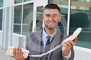 Businessman handing you a corded telephone