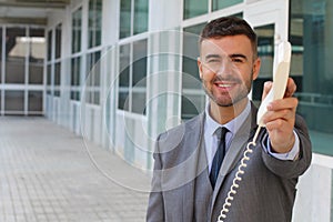 Businessman handing you a corded telephone