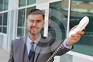 Businessman handing you a corded telephone