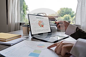 Businessman hands are analyzing charts, graphs, financial data. and accounting documents The displayed data calculates