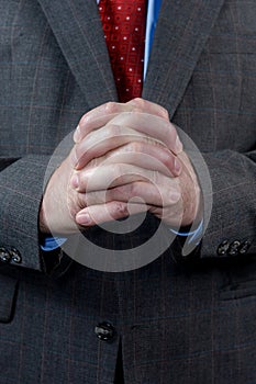 Businessman with hands clasped