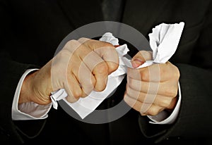 Businessman hands furiously tormenting document