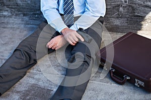 Businessman, hands and gun with suicide, stress and depression on ground with suitcase for risk or problem. Professional