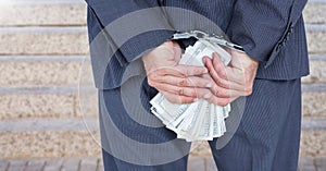 Businessman hands in handcuffs holding US dollars