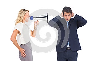 Businessman with hands on his ears because of megaphone